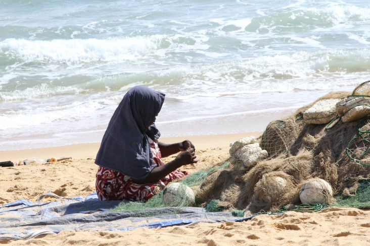 A woman in Trincomalee repairs nets 