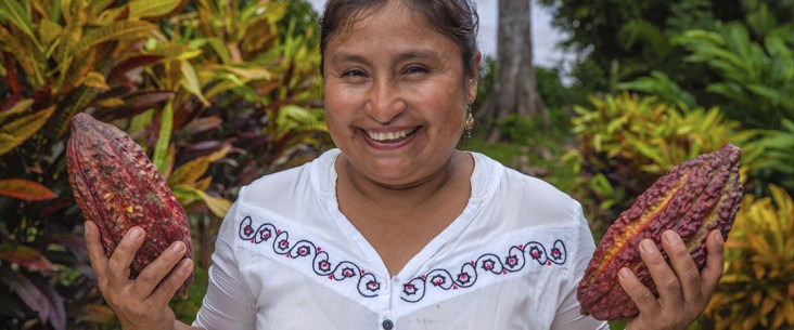 A smiling woman holds up her harvest