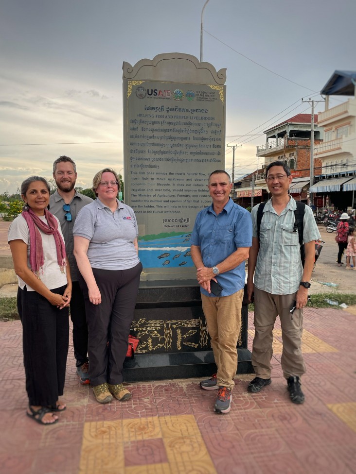 Team in front of fishing plaque 