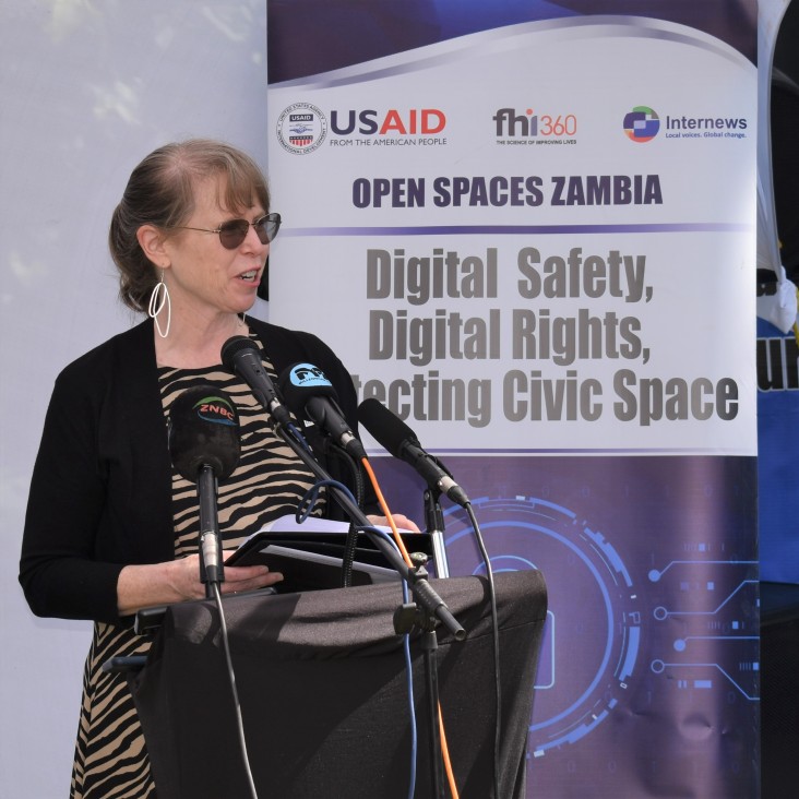 USAID Mission Director, Sheryl Stumbras, stands at a podium giving a speech.