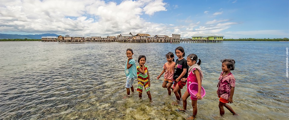 Photo: A group of Indonesian children collect shellfish from the shallow waters surrounding their seaside village.