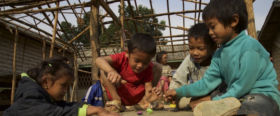 Children play with tops on a table