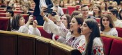 People take selfies in a Parliament chamber