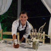 Girl prepares table for dinner at hotel.