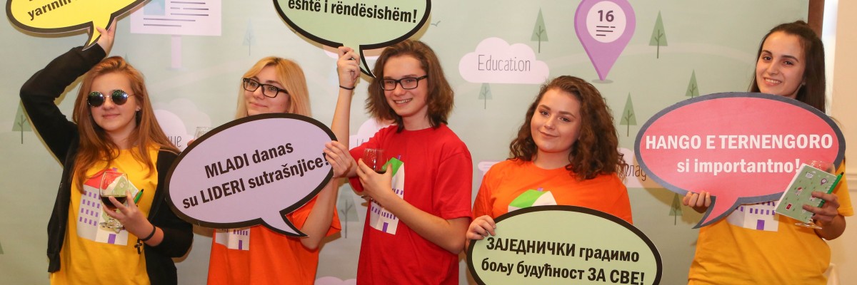 People pose with conversation bubble signs in various languages